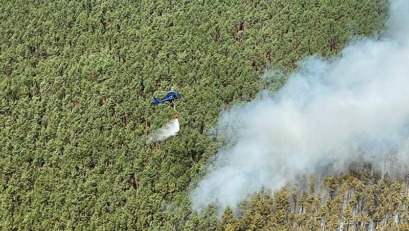 Ein Helikopter bei den Löscharbeiten (Bild: AFP)