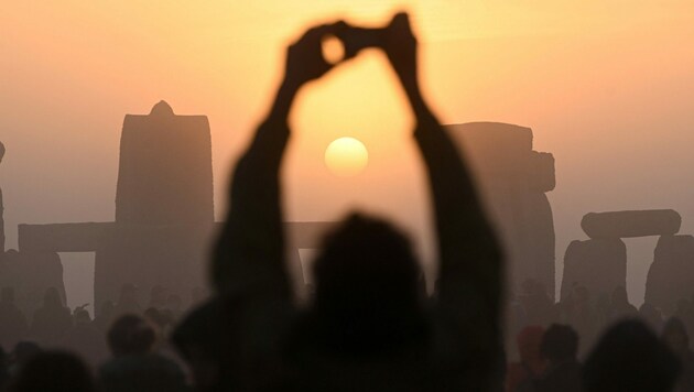 Als die Sonne am längsten Tag des Jahres um kurz vor fünf Uhr am klaren Horizont erschien, brandete Jubel unter den Anwesenden auf. (Bild: Justin TALLIS / AFP)