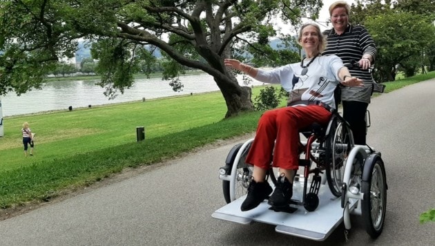 Linzplus-Gemeinderätin Renate Pühringer (im Bild mit Kepler Salon-Grand Dame Elfie Schulz) ist total begeistert vom Rollstuhl-Dreirad und hofft, dass ihr Antrag in der letzten Sitzung vorm Sommer Anklang findet. (Bild: linzplus)