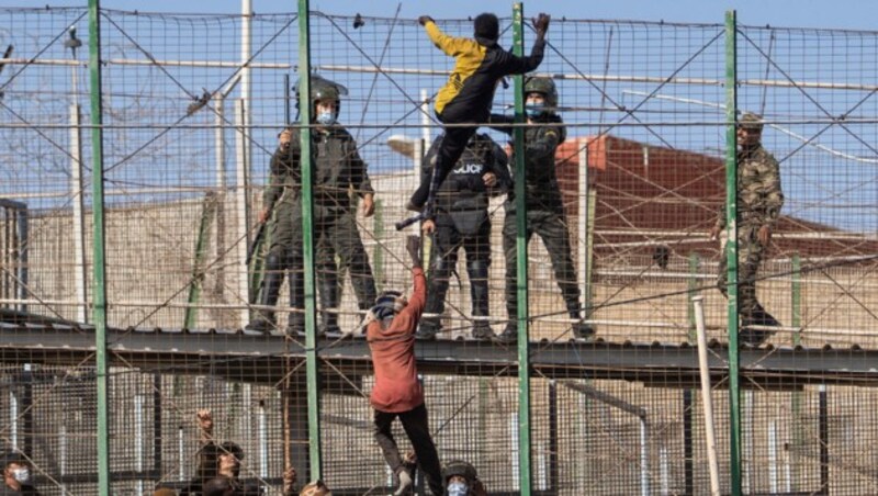 Migranten klettern über den Zaun, der die spanische Exklave Melilla von Marokko trennt. (Bild: The Associated Press)