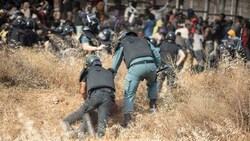 Ein Migrant wird von Polizeibeamten auf spanischem Boden festgehalten, nachdem er den Grenzzaun zwischen der spanischen Exklave Melilla und Marokko überquert hatte. (Bild: The Associated Press)