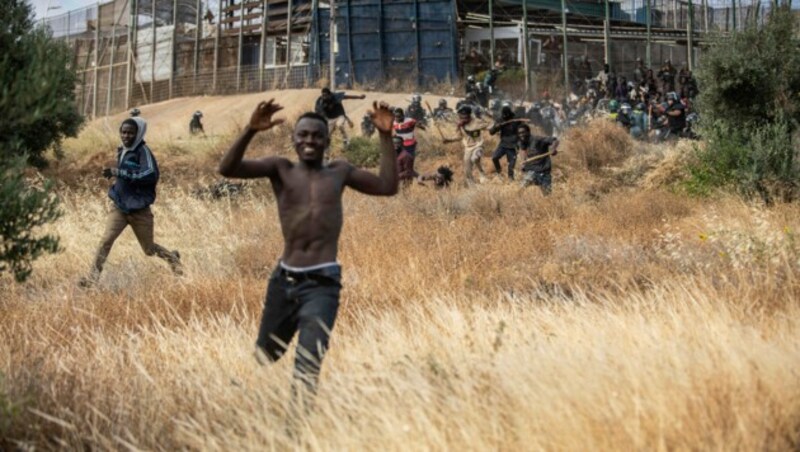 Migranten rennen auf spanischen Boden, nachdem sie die Zäune, die die spanische Exklave Melilla von Marokko trennen, überquert hatten. (Bild: The Associated Press)