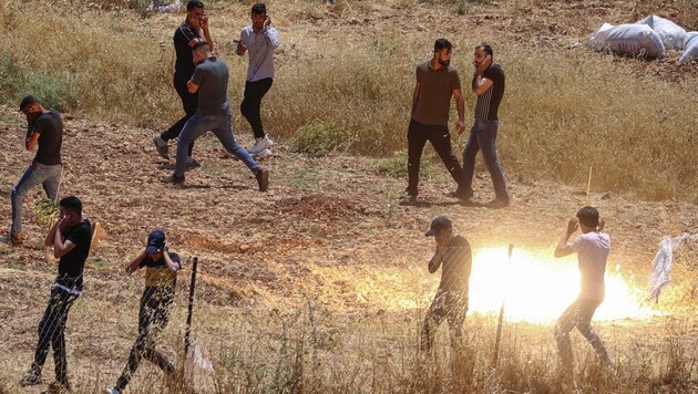 Palästinensische Demonstranten entfernen sich inmitten von Zusammenstößen mit israelischen Sicherheitskräften (Bild: AFP)
