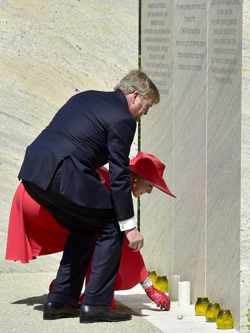 Der niederländische König Willem-Alexander und seine Gattin Maxima legen - wie zum Totengedenken im Judentum üblich - je einen Kieselstein an der Shoah-Namensmauer nieder. (Bild: APA/HANS PUNZ)