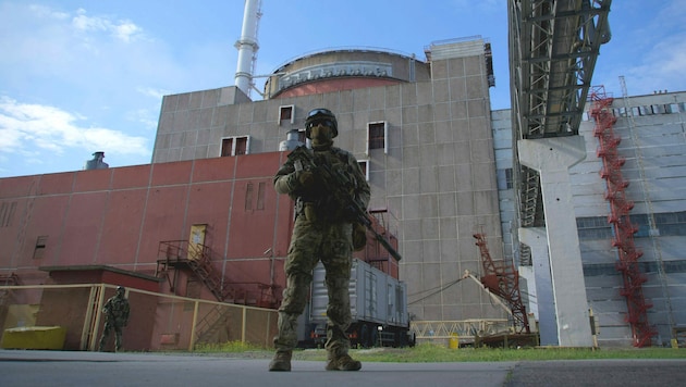 Ein russischer Soldat steht vor dem Nuklearkraftwerk Saporischschja Wache (Archivbild). (Bild: APA/AFP/Andrey BORODULIN)