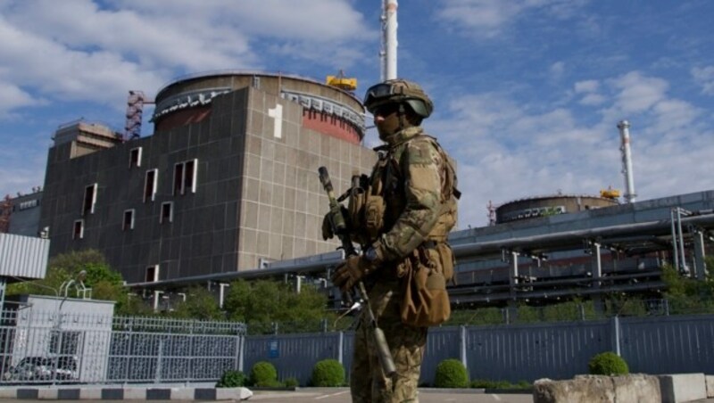 Ein russischer Soldat steht vor dem Nuklearkraftwerk Saporischschja Wache (Archivbild). (Bild: APA/AFP/Andrey Borodulin)