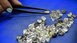 Qualitätskontrolle durch eine Mitarbeiterin des russischen Konzerns Alrosa (Bild: APA/AFP/Alexander NEMENOV)