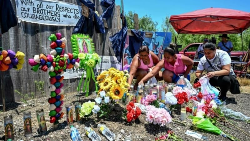 Menschen legen für die Opfer Blumen nieder. (Bild: AFP/CHANDAN KHANNA)