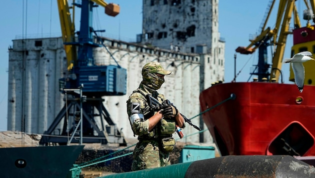 Ein russischer Soldat beim Bewachen eines Getreidespeichers im Hafen von Mariupol (Bild: AP)