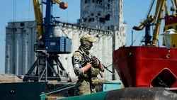 Ein russischer Soldat beim Bewachen eines Getreidespeichers im Hafen von Mariupol (Bild: AP)