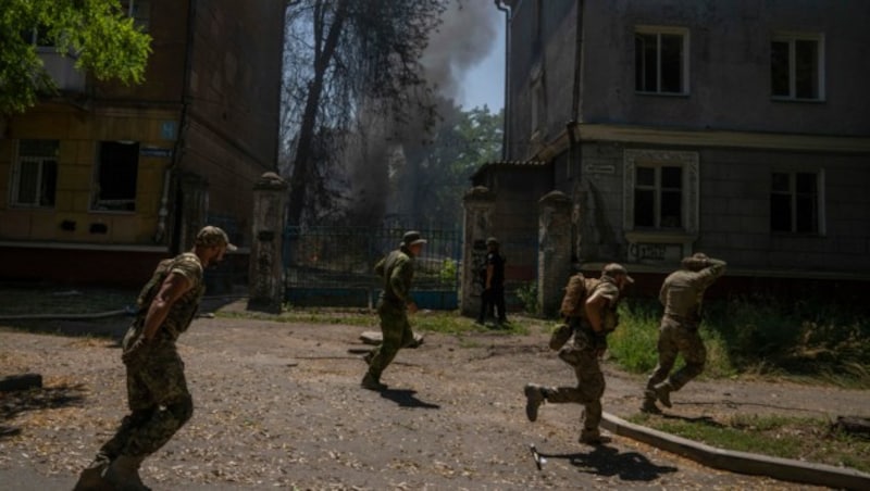 Ukrainische Soldaten fliehen vor einem Einschlag in Kramatorsk im Gebiet Donezk. (Bild: AP)