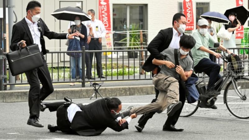 Unmittelbar nach dem Attentat: Abes Personenschützer ringen den Attentäter nieder. (Bild: APA/AFP/ASAHI SHIMBUN/STR)