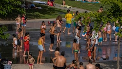 Kinder suchen in einem Park in Madrid Abkühlung. (Bild: AP/Manu Fernandez)