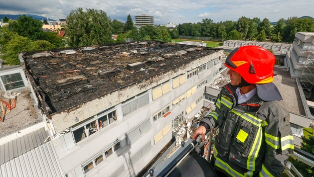 Branddirektor Reinhold Ortler inspizierte den massiven Schaden am Dach der Handelsakademie in Salzburg-Lehen von der Drehleiter aus. (Bild: Tschepp Markus)
