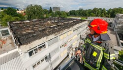 Branddirektor Reinhold Ortler inspizierte den massiven Schaden am Dach der Handelsakademie in Salzburg-Lehen von der Drehleiter aus. (Bild: Tschepp Markus)