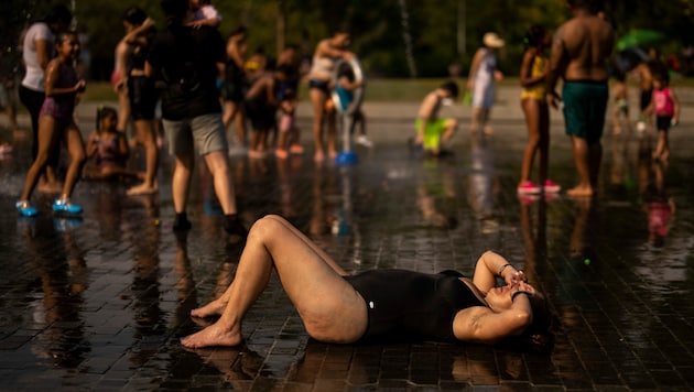 Im Madrid Rio Park suchen viele Spanier Erfrischung durch die zahlreichen Wasserfontänen. (Bild: Associated Press)