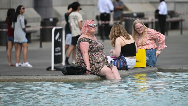 Der Brunnen am Trafalgar Square in London wird während der Hitzewelle zum Planschbecken umfunktioniert. (Bild: AFP)