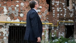 Außenminister Alexander Schallenberg Ende Juli 2022 vor einem zerstörten Wohnhaus in Irpin (Bild: APA/BMEIA/Michael Gruber)