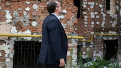 Außenminister Alexander Schallenberg Ende Juli 2022 vor einem zerstörten Wohnhaus in Irpin (Bild: APA/BMEIA/Michael Gruber)