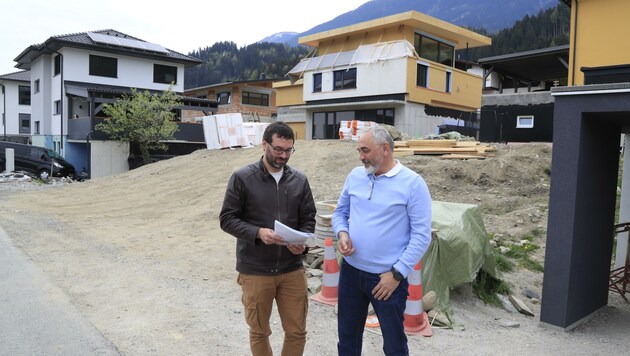 Mario Greil und Vater Robert vor dem Grundstück, um das seit 2019 gestritten wird. Die Nachbarn haben bereits gebaut. (Bild: Birbaumer Christof)