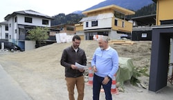 Mario Greil und Vater Robert vor dem Grundstück, um das seit 2019 gestritten wird. Die Nachbarn haben bereits gebaut. (Bild: Birbaumer Christof)