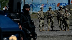NATO-Soldaten und kosovarische Polizisten an der Grenze zu Serbien bei Jarinje (Bild: APA/AFP/Armend NIMANI)
