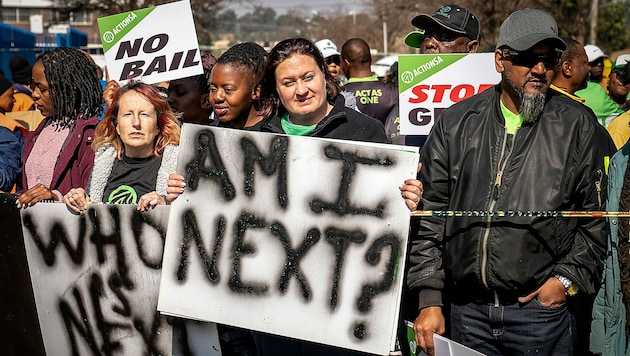 Demonstranten vor dem Gericht in Krugersdorp, wo die Verdächtigen vorgeführt wurden (Bild: AP)