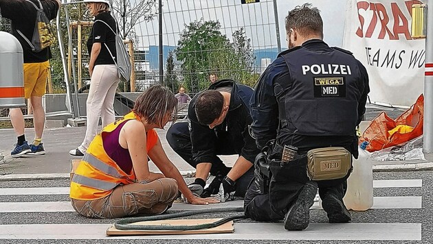 Behutsam „befreien“ Polizisten die festgeklebten Aktivisten. (Bild: letzte generation.at)