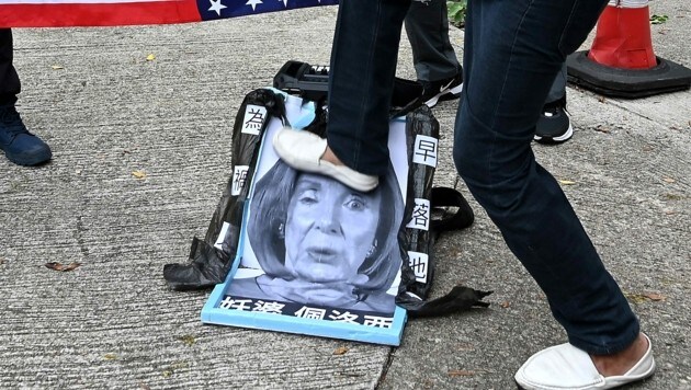 Wütende Chinesen trampeln auf einem Bild von Nancy Pelosi herum. (Bild: APA/AFP/Peter PARKS)