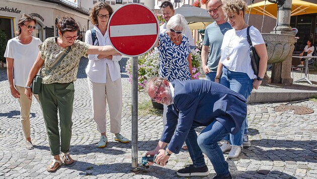 BM Christian Margreiter (Bild Mitte) schnitt ein störendes Verkehrszeichen kurzerhand selbst um. (Bild: Hubert Berger)
