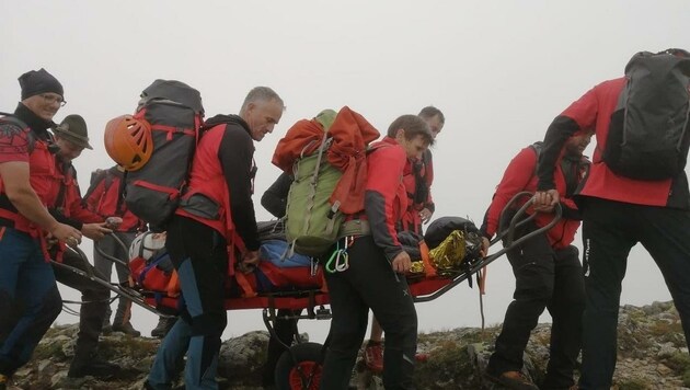 In der Gebirgstrage brachten die Bergretter den schwer Verletzten im dichten Nebel und teilweise mit Seilen gesichert ins Tal. (Bild: Bergrettung Steiermark)