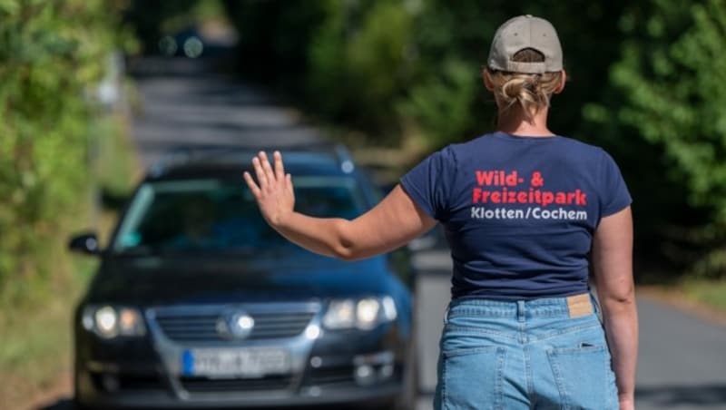 Eine Mitarbeiterin des Wild- und Freizeitparks Klotten stoppt einen Besucher - der Park wurde nach dem Todesdrama für mehrere Tage geschlossen. (Bild: APA/dpa/Harald Tittel)