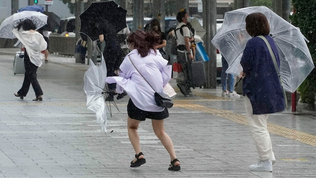 Menschen in Hamamatsu kämpften mit heftigen Winden. (Bild: Kyodo News via AP)