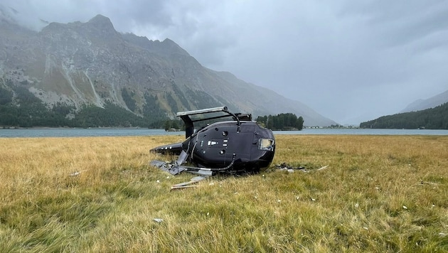 Der schwer in Mitleidenschaft gezogene EC 130 blieb auf der Seite liegen. (Bild: KAPO Graubünden)