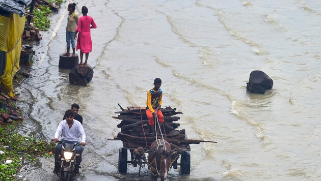 Menschen auf überfluteten Straßen in Indien (Bild: AFP)