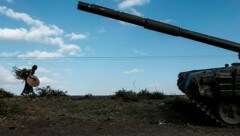 Archivbild aus dem Jahr 2020: Eine Landwirtin marschiert an einem verlassenen Panzer nahe der Stadt Mehoni vorbei. Dort sind nun wieder Kämpfe ausgebrochen. (Bild: APA/AFP/EDUARDO SOTERAS)