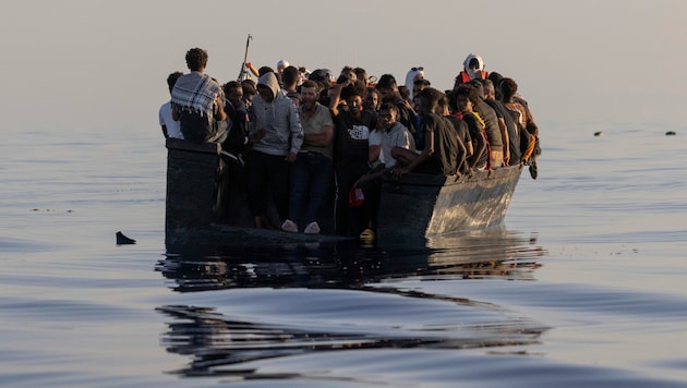 Migranten in einem Holzboot im Meer südlich von Lampedusa: Sie wurden am Samstag von der Ocean Viking aufgenommen. (Bild: AP)