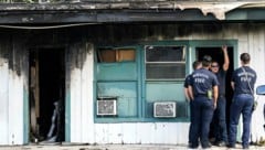 Feuerwehrleute inspizieren das Gebäude nach dem Löscheinsatz. (Bild: AP)