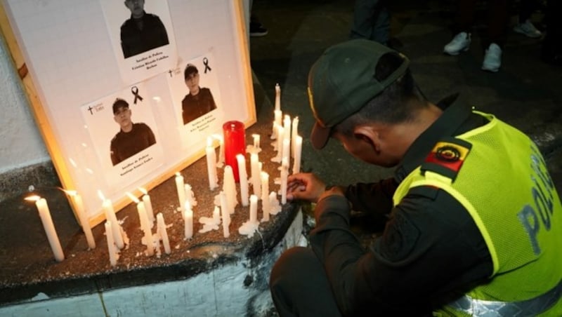 In Kolumbien wurden acht Polizisten bei einem Anschlag getötet. Kollegen zündeten für die Verstorbenen Kerzen an. (Bild: AFP )