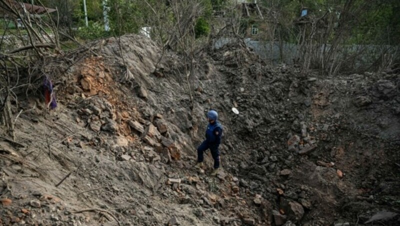 Ein ukrainischer Minenräumer untersucht einen Krater nach einem Raketeneinschlag in Charkiw. (Bild: AFP)