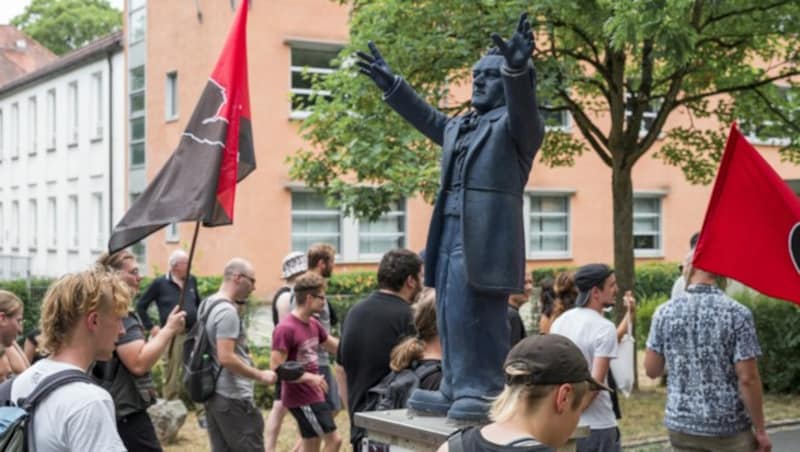 25. Juli 2022: Teilnehmer nehmen an einer Anti-Wagner-Demonstration nahe des Festspielhauses teil und laufen an einer Richard-Wagner-Statue vorbei. (Bild: APA/dpa/Daniel Vogl)