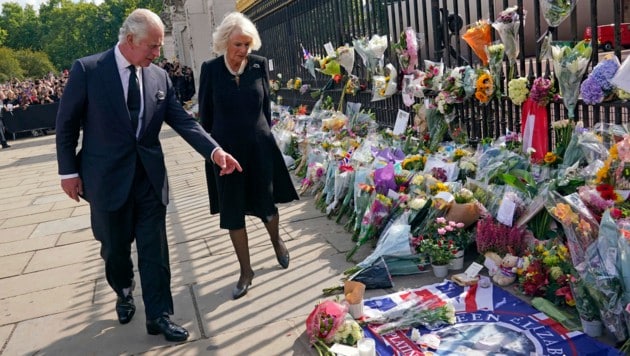 König Charles und Königin Camilla betrachteten die zahllosen Blumen, die Trauernde vor dem Buckingham-Palast abgelegt hatten. (Bild: PA)