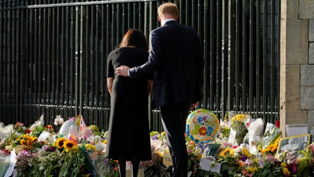 Harry legt beim Betrachten der Blumen und Grußbotschaften vor Schloss Windsor die Hand auf den Rücken seiner Frau Meghan. (Bild: Alberto Pezzali / AP / picturedesk.com)