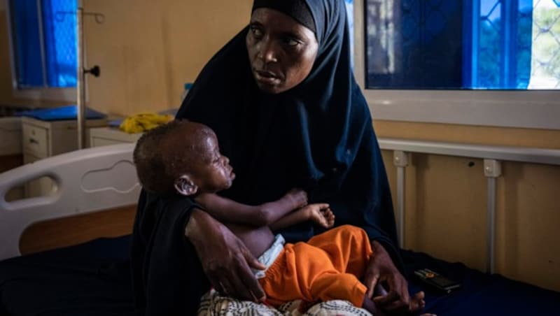 Eine Mutter hält ihr unterernährtes Baby in einem Spital in Somalia (Bild: AFP)