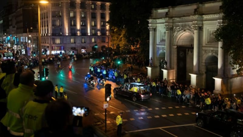 Menschen versammeln sich in der Nähe des Marble Arch, als der Leichenwagen mit dem Sarg von Königin Elizabeth II. zum Buckingham-Palast in London fährt. (Bild: The Associated Press)