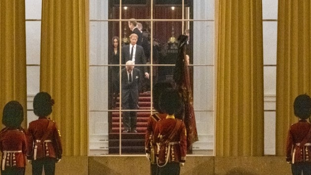 Den Kopf gebeugt, hinter sich seinen Sohn Prinz Harry und Herzogin Meghan. So wartete König Charles im Buckingham-Palast auf die Ankunft des Sarges der verstorbenen Queen. (Bild: Jeremy Selwyn / PA / picturedesk.com)