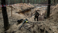 Mehr als 440 Leichen sollen im Wald in Isjum gefunden worden sein. (Bild: AP/Evgeniy Maloletka)
