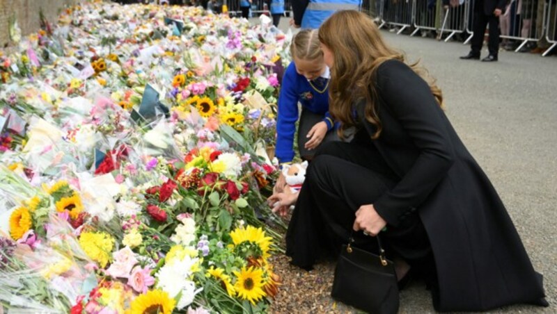 Prinzessin Kate rührte ein Schulmädchen zu Tränen, weil dieses gemeinsam mit der Dreifach-Mama ihre Blumen und ihren Plüsch-Corgi ablegen durfte. (Bild: TOBY MELVILLE / REUTERS / picturedesk.com)