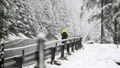 Ein Tourenradfahrer im Schneefall auf der Passstraße in Obertauern. (Bild: APA/BARBARA GINDL)