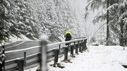 Ein Tourenradfahrer im Schneefall auf der Passstraße in Obertauern. (Bild: APA/BARBARA GINDL)